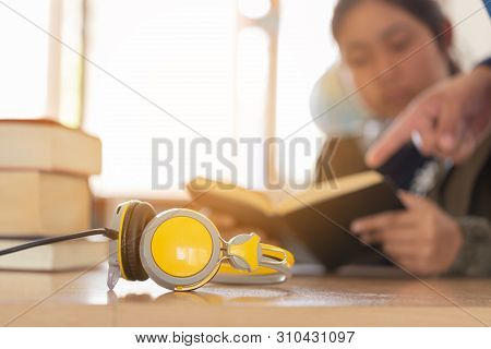 Books And Headphones As Audio Books Concept On  High School Or University Library Background