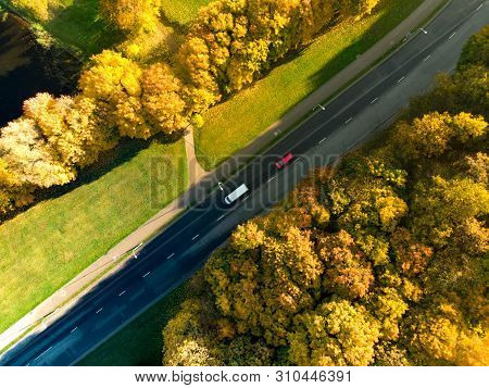 Aerial Top Down View Of Autumn Forest With Two-lane Road Among Autumn Yellow And Orange Trees. Beaut