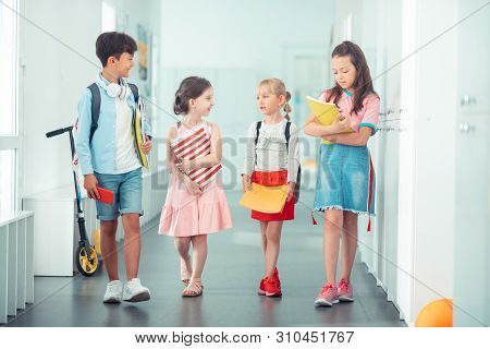 Boy And Girls Going To Classroom And Discussing Schedule