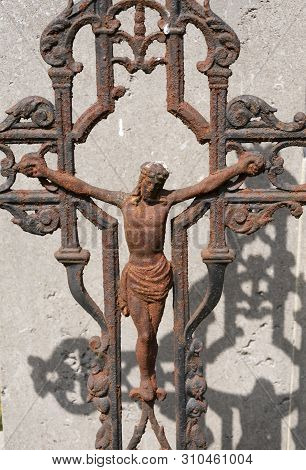 Sint Gillis Waas, Belgium, 08 July 2019. Old Rusted Cross With Jesus Christ, The Shadow Falls On A C