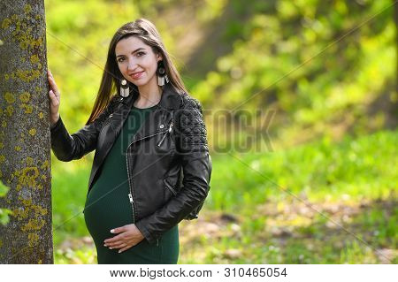 Portrait Of A Beautiful Pregnant Brunette. Young Beautiful Pregnant Woman With Long Dark Hair.