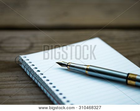 Pen And Notebook On The Desk Table