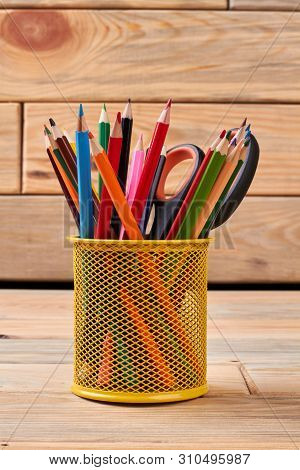 Yellow Metal Holder With Multicolored Pencils. Stationery Supplies On Wooden Background. Concept Of 