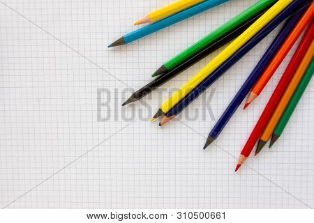 A Blank Sheet Of Paper In The Box On It Are Colored Pencils.