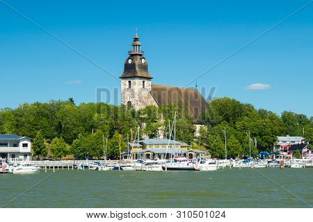 Naantali, Finland - 28 June, 2019: View From The Sea Of Naantali Harbor And Medieval Stone Church At