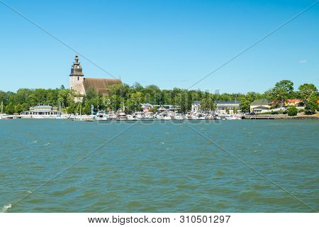 Naantali, Finland - 28 June, 2019: View From The Sea Of Naantali Harbor And Medieval Stone Church At