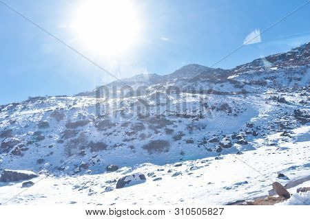 Sun On Top Of Snow Cover Himalaya Range. Frozen Rocky Peak Filled With Deep Snow Illuminate Rising S