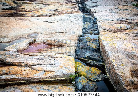 A Crack With Black Intrusive Igneous Basalt Dike Rock And Granite At Schoodic Point In Acadia Nation