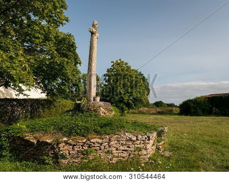 Old Monument Made Of Stone Standing On A Meadow In France
