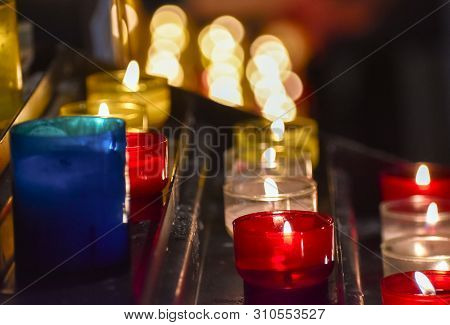 Candles Inside A Church. Sensation Of Religiosity And Tranquility. Bokeh Lights As Space For Text