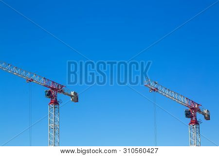 Industrial Construction Cranes Or Column-jib Cranes With Cabin Are Working On The Construction Site 