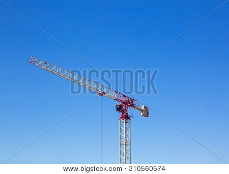 Industrial Construction Crane Or Column-jib Crane With Cabin Works  On The Construction Site And Blu