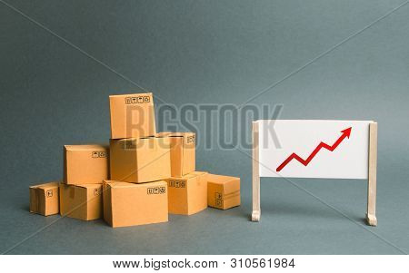 Plenty Of Cardboard Boxes And Whiteboard With Red Positive Trend Chart. Increasing Consumer Demand. 