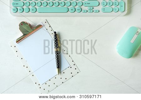 White-blue Computer Keyboard And Mouse, A Clipboard And A Black Polka Dot White Pen.