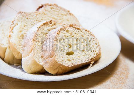 Poudered Slices Of Bread In A White Plate On The Wooden Table