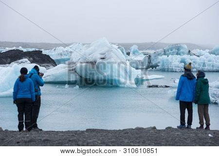 Tourists Admiring The Icebergs At Jokulsarlon, Iceland