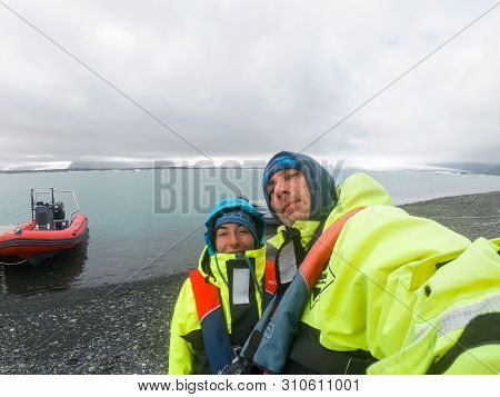 Couple Making A Selfie In Safety Inflation Clothes In Jokulsarlon, Iceland