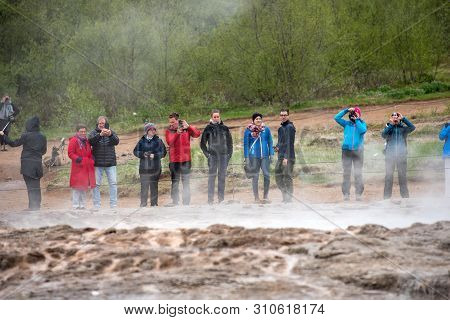Tourists Visiting Strokkur Geyser In Iceland