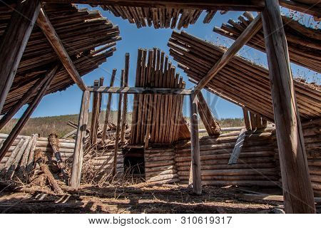 View Inside The Old Wooden Yurt. Ruins. Grass Is Growing, Through The Roof You Can See The Sky.