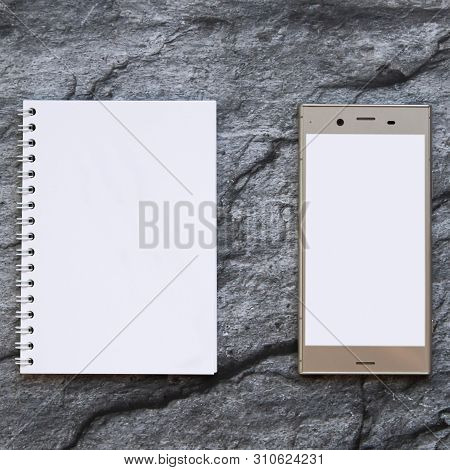 Blank Smartphone And Clear Paper Notepad. Top View.