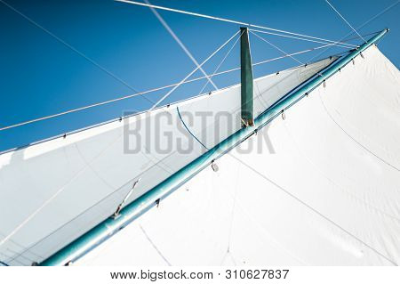 White Cloth Fabric, Masts And Ropes Close-up On The Sail Of Tri-yacht Or Yacht Sailing Boat