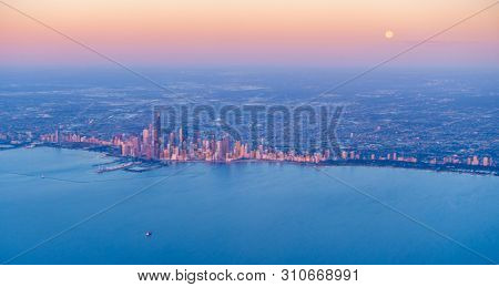 Scenic aerial view of full moon setting over Chicago downtown at sunrise