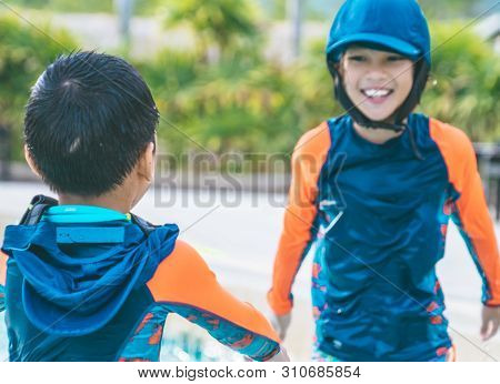 Two Asian Siblings In Playing Together In Water Aqua Park Pool.