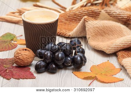Cup Of Coffee, Grapes, Walnuts, Checkered Plaid And Dry Leaves On Wooden Boards. An Autumn Still Lli