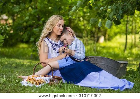Portrait Of Happy Caucasian Mother With Her Upset Little Kid. Posing With Basket Full Of Bread Rings