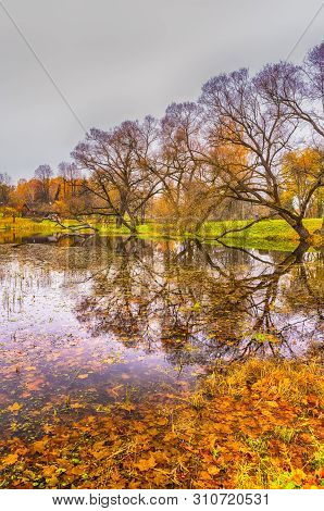 Lonely Wooden House Behind Tranquil Lake In Foreground. Vertical Image Composition