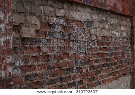 The Wall Is Made Of Bricks Of Red, Gray, Black Colors, Having A Pronounced Texture.