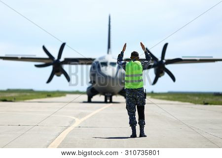 Boboc, Romania - May 22, 2019: Ground Personnel Is Aircraft Marshalling An Alenia C-27j Spartan Mili