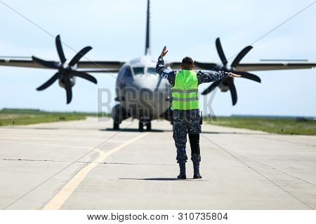 Boboc, Romania - May 22, 2019: Ground Personnel Is Aircraft Marshalling An Alenia C-27j Spartan Mili