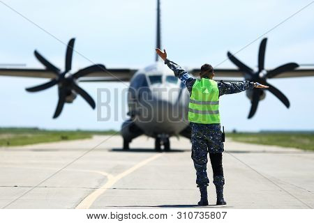Boboc, Romania - May 22, 2019: Ground Personnel Is Aircraft Marshalling An Alenia C-27j Spartan Mili