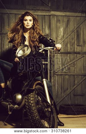 Biker, Girl Or Beautiful Woman With Blond, Long Hair In Leather Jacket Sitting On Vintage Motorcycle