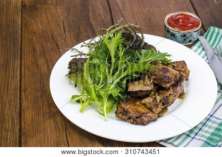 Slices Of Fried Liver, Green Leaves Of Salads