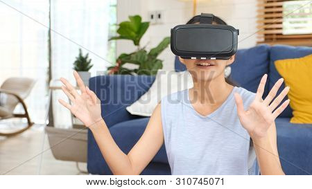 Young Beautiful Asian Woman Exciting In Vr Headset Looking Up And Trying To Touch Objects In Virtual