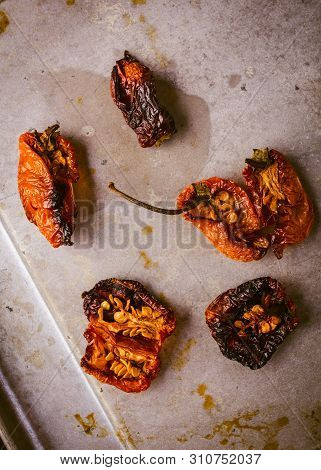 Grouping Of Oven Roasted Habaneros On A Baking Tray That Have Been Cut Open.