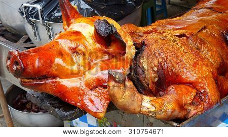 Big Whole Roasted Pig Is On The Table And Ready For Sale At The Opened Market In Cuenca. Street Food