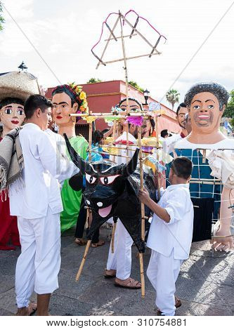 Oaxaca, Oaxaca, Mexico- July 6, 2019: Boys With A Torito, Structure With Fireworks And Giant Puppets