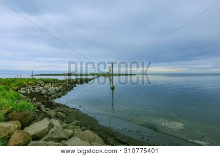 Island Grotta Near Reykjavik In The Morning With Clouds In The Sky. Stone Coast On The Atlantic Ocea
