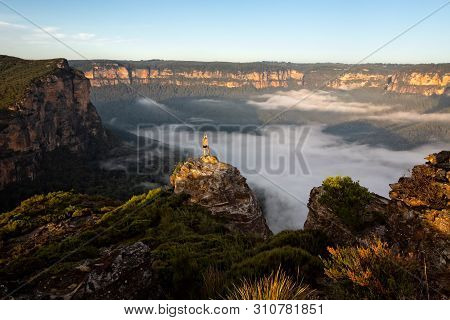 Hiker Taking In Magnificent Views Of Mountains And Valleys As The First Light Hits The Sandstone Esc
