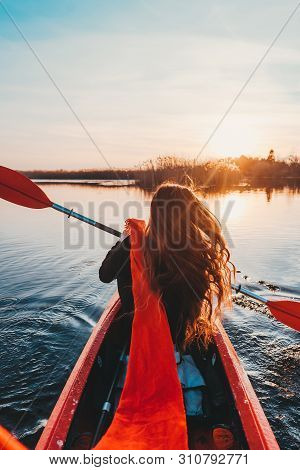 Back View Of Happy Cute Girl Holding Paddle In A Kayak On The River