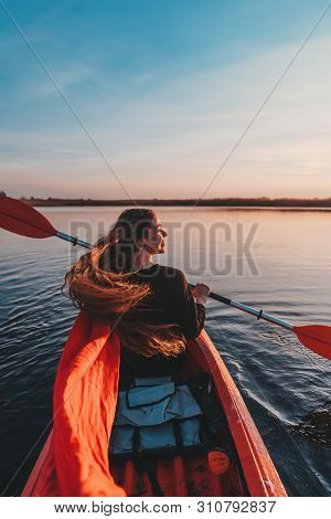 Back View Of Happy Cute Girl Holding Paddle In A Kayak On The River