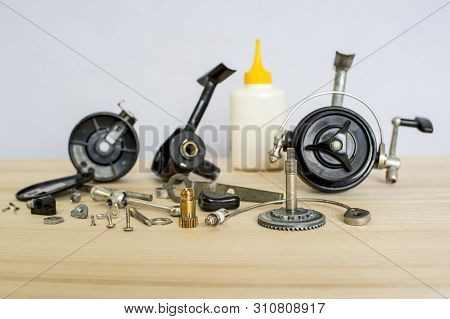 A Fishing Spinning Reel As A Whole And A Second Similar Completely Disassembled. Concept: Parts Of A
