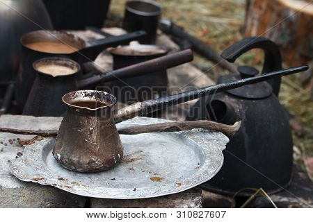 Boiling Coffee In Turkish Cezva On A Grate Over A Burning Bonfire, A Camping Concept