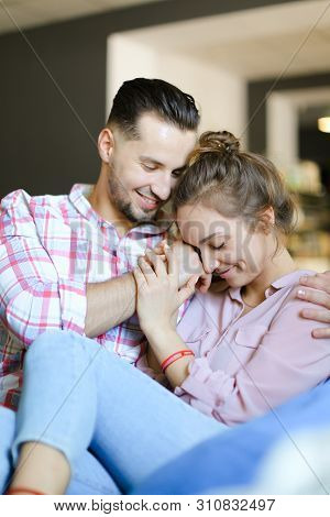 Young Smiling Boy Hugging Gilfriend Wearing Jeans.