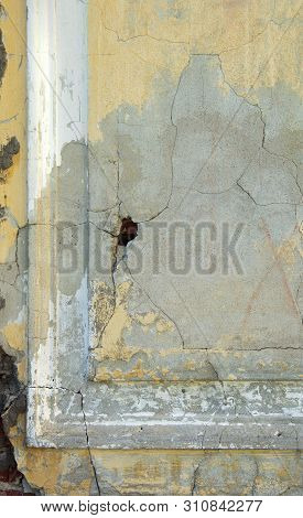 Wall Of An Old House With Crumbling Plaster