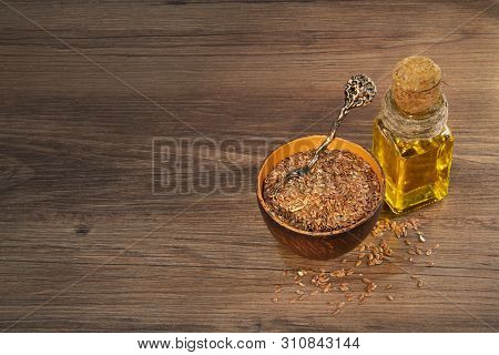 Flax Seeds And Oil On Wooden Table