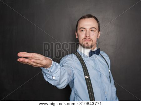 Handsome Man Showing On Something On His Hand On Blackboard